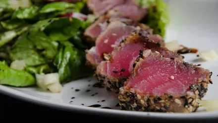 Atún con verduras en un plato muy colorido.