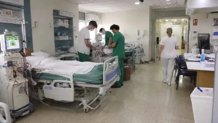 Sala con pacientes y enfermeros y enfermedad atendiéndolos.