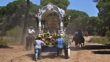 Romeros empujando una carreta con el simpecado camino del Rocío.