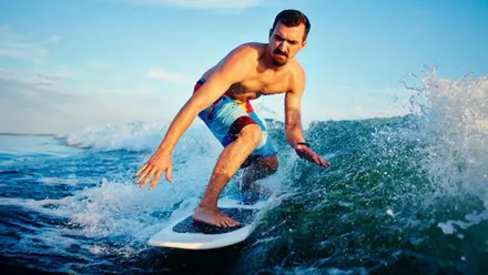 Hombre sobre una tabla surfeando.
