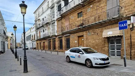 Calle de El Puerto con una parada de taxi y un coche.