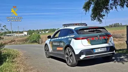 Coche de la Guardia Civil a la entrada de un paraje agreste.