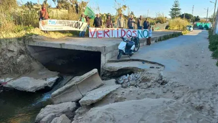 Pancarta sobre una aliviadero de aguas en Sanlúcar, es una protesta contra los vertidos.