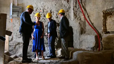 Patricia del Pozo y Bruno García observan los trabajos de rehabilitación del Teatro Romano de Cádiz desde una zona elevada del yacimiento. En primer plano se aprecian estructuras arqueológicas del monumento. La intervención está financiada por la Junta de Andalucía.