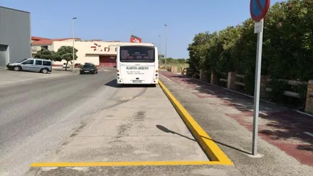 Calle con la señalización pintada en amarillo y un autobús aparcado.
