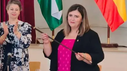 La alcaldesa de Conil, Inmaculada Sánchez, tomando posesión. Lleva vestido rosa y chaqueta negra.