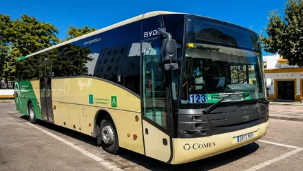 Autobús esperando cargar pasajeros, en color crema y verde.