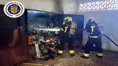 Dos bomberos extinguen el incendio en el garaje.