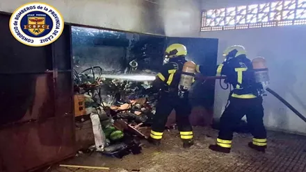Dos bomberos extinguen el incendio en el garaje.