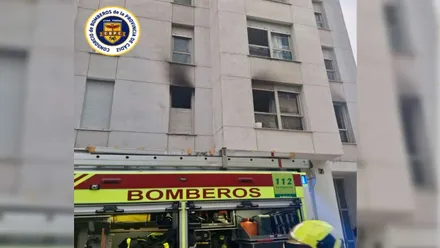 Camión de bomberos amarillo y rojo en la calle afectada.
