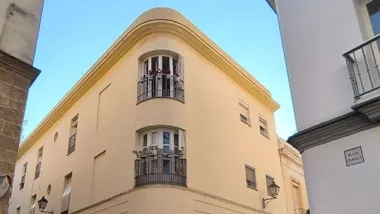 Una curiosa esquina de Cádiz, con macetas en los balcones modernos y bajo un sol azulado. Foto: José Luis Porquicho Prada.