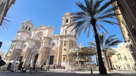 La Catedral de Cádiz, con el tiovivo ya operativo en la plaza, bajo un cielo azulísimo. Foto: José Luis Porquicho Prada.