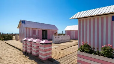 Casetas nuevas, en blanco y rosa, en Camposoto, en la playa.