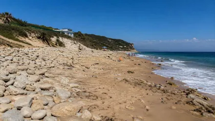 Muchas rocas y poca arena en la playa de Caños de Meca.