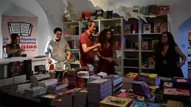 Varias personas observan libros en la Casamata de la Librería Plastilina en la Feria del Libro 2026 de Cádiz