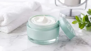 Tarro verde con crema blanca de tratamiento antiedad.