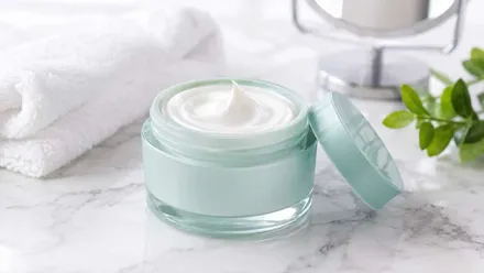 Tarro verde con crema blanca de tratamiento antiedad.