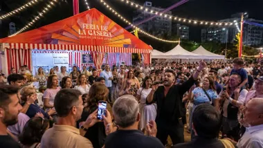 Personas en la Feria de La Casería en San Fernando, alrededor a un animador con camisa negra.