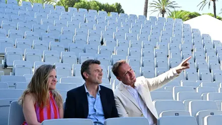 La teniente de alcalde de Cultura, Maite González, el alcalde de Cádiz, Bruno García, y el teniente de alcalde de Urbanismo, José Manuel Cossi, permanecen sentados en las nuevas gradas del Teatro José María Pemán durante la presentación de la reapertura del recinto cultural. Al fondo se aprecia parte de la estructura renovada del espacio escénico del Parque Genovés.