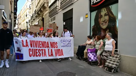 Vecinas con carros de la compra observan el paso de la manifestación por la vivienda en Cádiz. Foto: Eulogio García.
