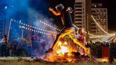 Hombre salta una hoguera en la Noche de San Juan.