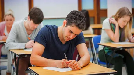 Varias personas, chicos y chicas, en un examen.