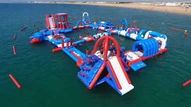 Playa de La Barrosa con atracciones hinchables en el agua.