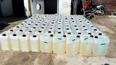 Garrafas de gasolina que muestran el combustible en el patio de una casa cerca de una zona de almacén.