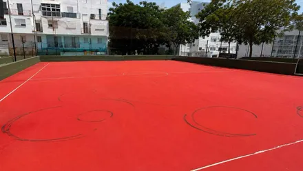 Pista de color ladrillo con daños en marcas negras.