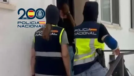 Tres policías nacionales entrando a una oficina en Puerto Real.