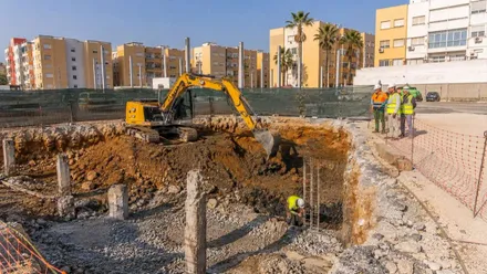 Agujero y una excavadora haciendo la obra de la piscina de San Fernando.