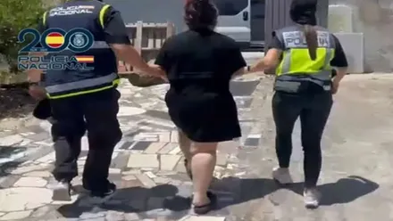 Dos agentes de la Policía Nacional con una de las detenidas.