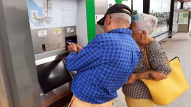 Dos personas mayores haciendo una recarga en el cajero del Trambahía.