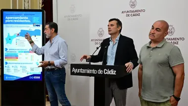 José Manuel Verdulla interviene durante una rueda de prensa en el Ayuntamiento de Cádiz mientras señala una pantalla con la infografía del nuevo sistema de estacionamiento regulado. A su lado aparecen el alcalde, Bruno García, y otros responsables municipales durante la presentación de las nuevas zonas de aparcamiento para residentes.