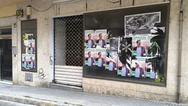 Algunos carteles de Adelante Andalucia en un escaparate de una tienda cerrada. Foto: José Luis Porquicho Prada.