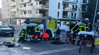 Bomberos y policía junto al vehículo volcado.