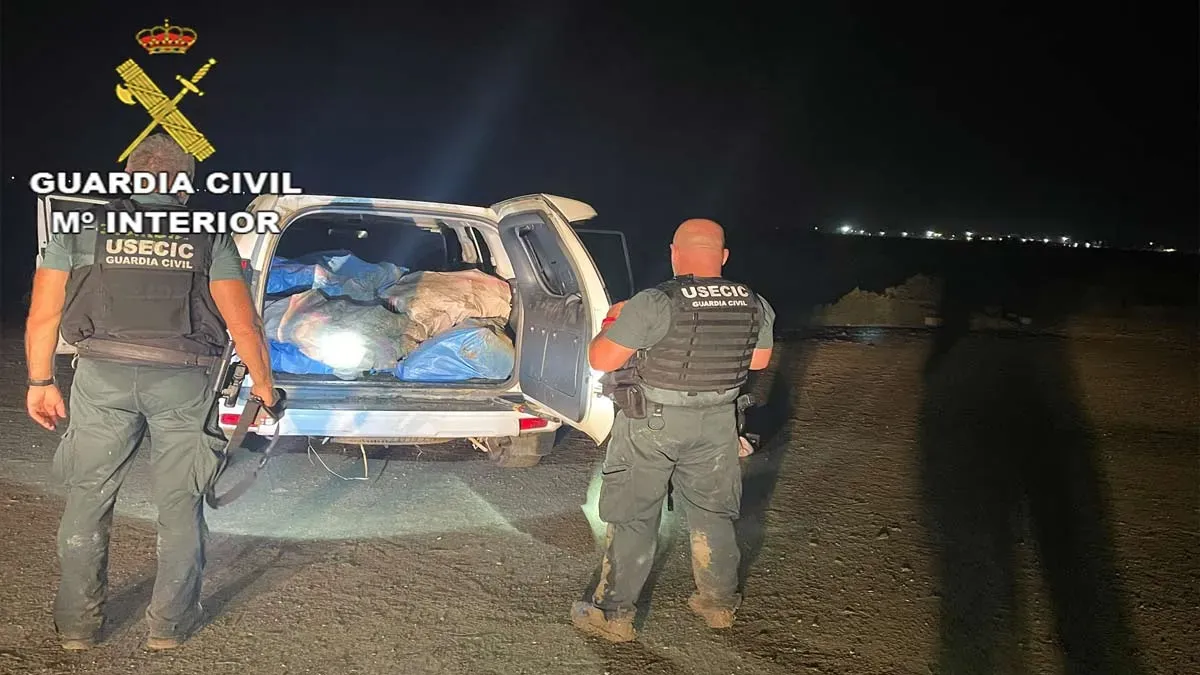 Coche 4x4 cargado con fardos de droga y agentes de la Guardia Civil en el exterior.