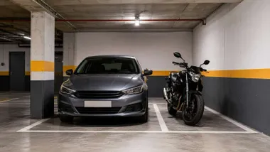 Coche y moto aparcados en un garaje de una viviendas.