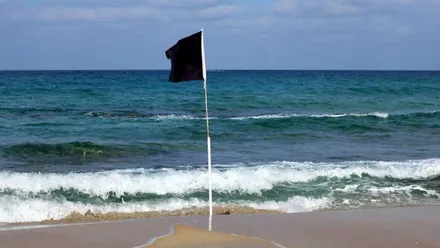 Bandera negra en una playa.