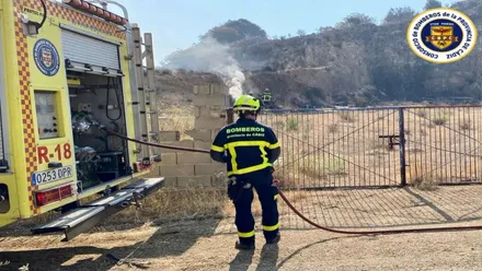Camión de bomberos y bombero ante una de las zonas con fuego.