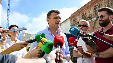 El alcalde de Cádiz, Bruno García, atiende a los medios con numerosos micrófonos y periodistas ante él.