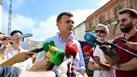 El alcalde de Cádiz, Bruno García, atiende a los medios con numerosos micrófonos y periodistas ante él.