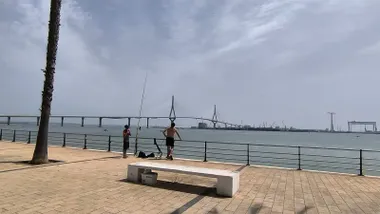 Dos personas pescan en la Bahía en Cádiz, con el Puente Constitución de 1812 al fondo.