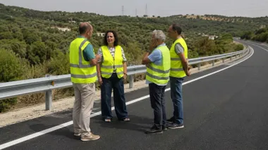 Grupo de personas con chalequillos reflectantes en la carretera rehabilitada.