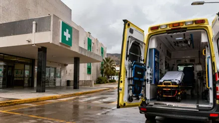 Hospital y una ambulancia con el portón trasero abierto.