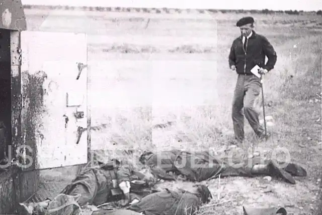 Fotografía en blanco y negro de la Guerra Civil en la que José María Pemán aparece de pie junto a los cadáveres de varios combatientes del bando republicano en un campo abierto. Imagen conservada por el Museo del Ejército.