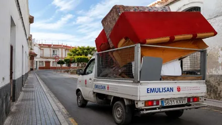 Camión transportando un sofá rojo.
