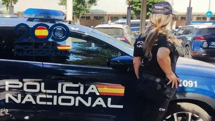 Agente junto a un vehículo de la Policía Nacional.