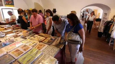 Una de las casamatas de librerias de la Feria del Libro de Cádiz con gran presencia de personas observando los libros