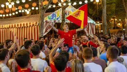 Aficionado con una bandera de España entre la multitud en la Feria.